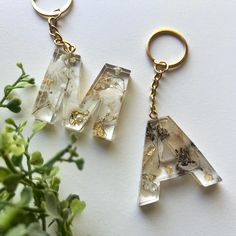 two pieces of glass sitting next to each other on a white surface with flowers in the background