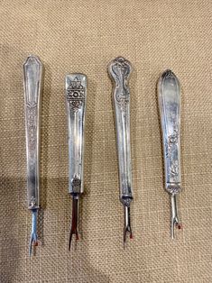 four different types of silverware sitting on top of a cloth covered floor next to each other