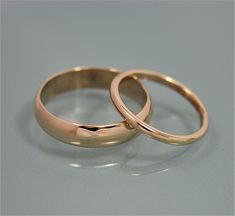 two gold wedding rings sitting side by side