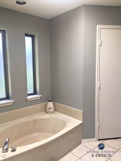 an empty bathroom with two windows and a bathtub