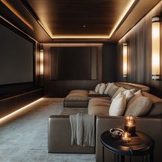 A sophisticated home theater with deep, plush leather sectional seating that invites comfort. The room is adorned with modern, sleek lighting fixtures, providing a warm ambient glow. Dark paneling on the walls enhances the cinema-like atmosphere, while the large projection screen awaits the next feature. A side table holds candles, adding a touch of warmth to this luxurious space. Neutral Theatre Room, Movie Room Ideas Small Home Theaters, Theatre Room Design, Small Home Theater Ideas, Hack My Home, Luxury Home Cinema Room, In Home Movie Theater, Cinema Room Design, Home Theatre Design