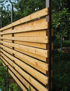 a wooden fence in the middle of some trees