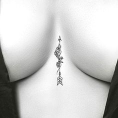 a woman's breast with an arrow tattoo on her left side, in black and white