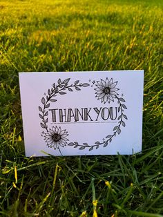 a thank you card sitting in the grass