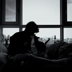 a black and white photo of a person sitting on a couch with a cat in their lap