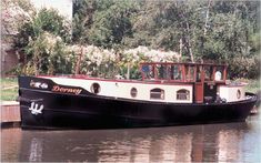 a black and white boat on water next to trees