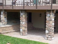 two people are standing on the balcony of a house with stone pillars and balconies