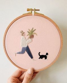 a person is holding up a cross - stitch pattern with a dog and palm tree on it