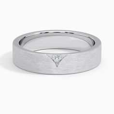 a white gold wedding band with a diamond in the center and a small triangle on top