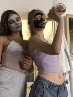 two women with facial masks on and one holding a wine glass in front of her face