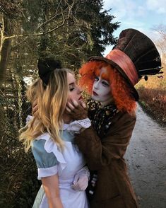 two women dressed up as alice and the mad hatter, one with red hair