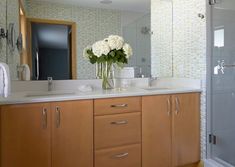 a bathroom with two sinks and a large mirror on the wall next to the shower