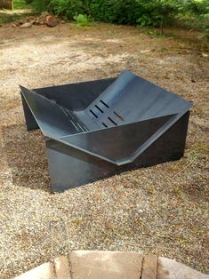 a metal bowl sitting on top of a gravel field