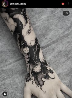 a person with tattoos on their arm and hand is holding onto the wrist that has an image of a rabbit