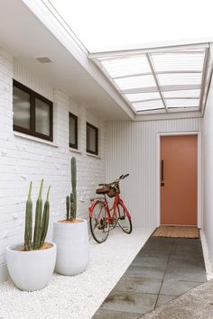 a red bike parked next to two white planters