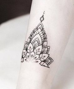 a black and white photo of a woman's leg with a flower tattoo on it