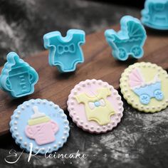 some baby items are sitting on a wooden board and ready to be used as fondant decorations