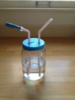 a glass jar with two straws in it