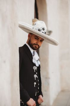 a man wearing a white hat and black suit