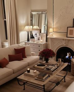 a living room filled with furniture and a fire place in front of a mirror on the wall