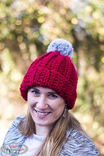 a woman wearing a red knitted hat and smiling