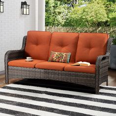 an orange couch sitting on top of a white and black rug