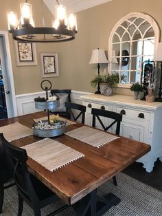 a dining room table with place mats on it and some lights hanging above the table