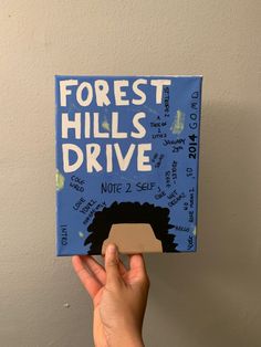 a hand holding up a book with writing on it that reads forest hills drive not to sell