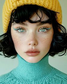 a woman with freckled hair and blue eyes wearing a yellow knitted hat