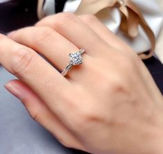 a woman's hand with a ring on her finger and a bow tie around it