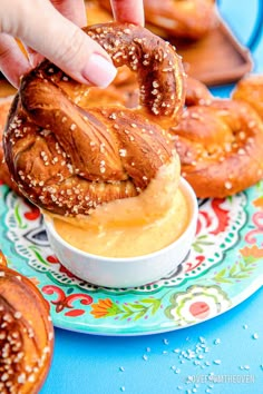 a person dipping some pretzels into a bowl