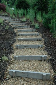 a set of stone steps leading up to the top of a hill in a garden