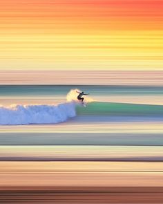 a person riding a surfboard on a wave in the ocean at sunset or sunrise