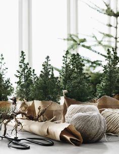 several different types of christmas trees are on the table next to scissors and twine