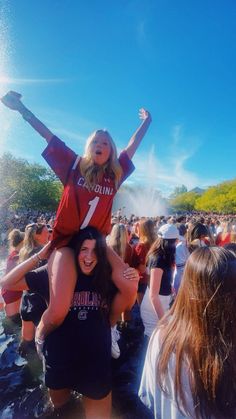 two girls are in the water with their arms around each other and one girl is on her shoulders