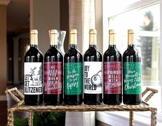 six bottles of wine sitting on top of a wooden shelf in front of a window