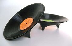 two black records sitting side by side on top of each other, one with an orange disc