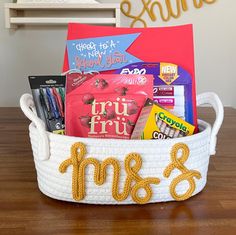 a white basket filled with books and snacks