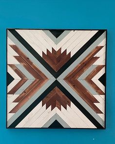 a wooden wall hanging on the side of a blue wall with black and white stripes