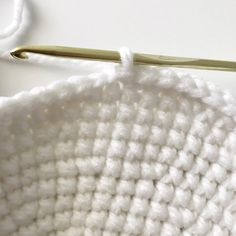 the crochet is being worked on with a knitting needle