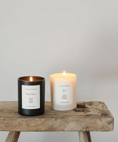 two candles sitting on top of a wooden table