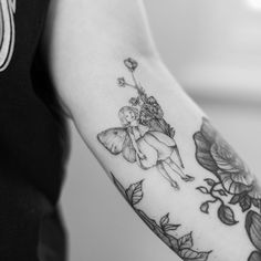 a woman with a tattoo on her arm holding a flower and a butterfly in the air