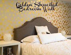 there is a bed with white pillows and yellow polka dots on the wall behind it