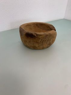 a wooden bowl sitting on top of a white counter next to a wall and floor