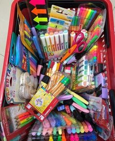 a red container filled with lots of different colored pens and markers