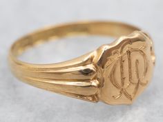 "This intricate signet ring is crafted from yellow gold, featuring a classic shield shape and beautiful etched design. Luxurious and elegant, this ring offers a timeless look that's perfect for everyday wear. Metal: 18K Yellow Gold Top Measurements: 8.2 x 9.6 mm, Shield Shape Ring Size: 7.50 Marks: \"[JS&S18\" Stamped on the inside band SKU #: A29671 Each piece has been identified and graded by a Graduate Gemologist who has been certified by the Gemological Institute of America (GIA). We have six brick-and-mortar storefronts in Maine, Massachusetts, and New Hampshire and have been in business for over 25 years! Please visit our Shop's About Page or our website for more information about our jewelry. For questions about diamond grading, we recommend the  Gemological Institute of America (GI Art Deco Signet Ring, Signet Ring Gold, Gold Shield, Hair Jewellery, Top Measurements, Pocket Watch Chain, Gold Signet Ring, Jewelry Style, Gold Top