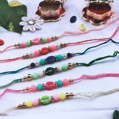 several different colored beads on a white table