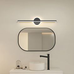 a bathroom with a sink, mirror and light on the wall above it's counter