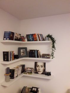 three white shelves filled with books on top of each other next to a desk and chair