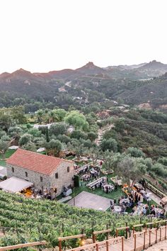 an aerial view of a vineyard with lots of vines and people standing around the building